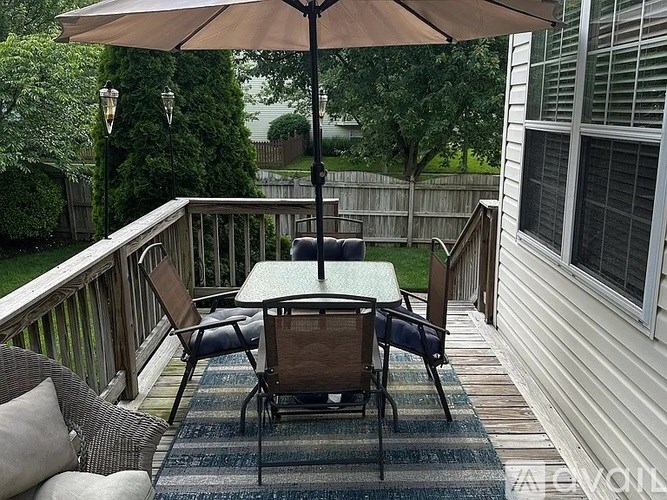 A patio with a table and chairs under an umbrella.