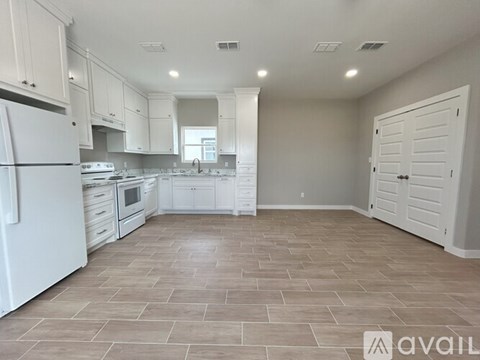 A kitchen with white appliances and cabinets is available for rent.