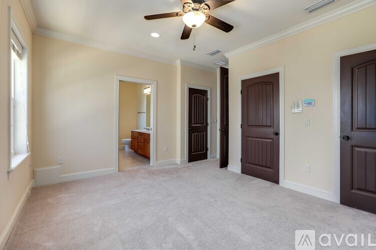 A spacious room with a ceiling fan and carpeted floor.