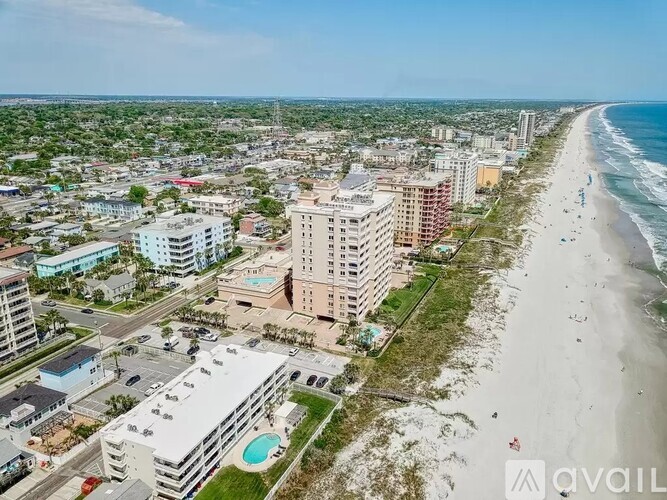 A beachfront city with apartment buildings and a pool.