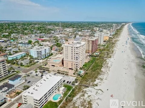 A beachfront city with apartment buildings and a pool.