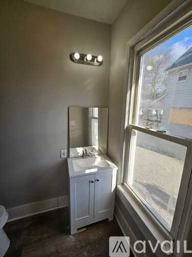 A bathroom with a white cabinet and a mirror above a sink.