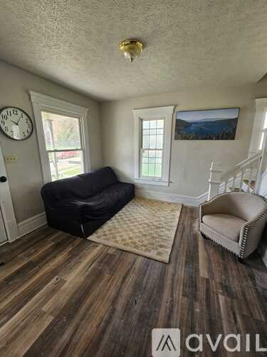 A living room with a black couch and a beige chair.