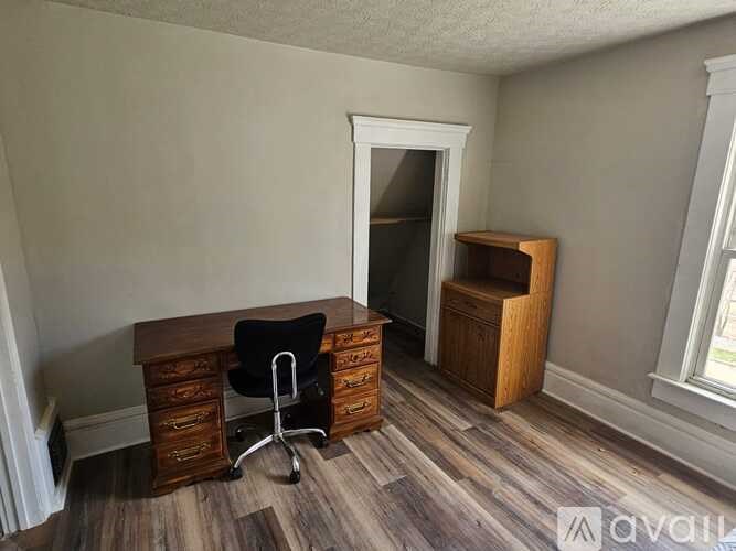 A room with a wooden desk and chair.