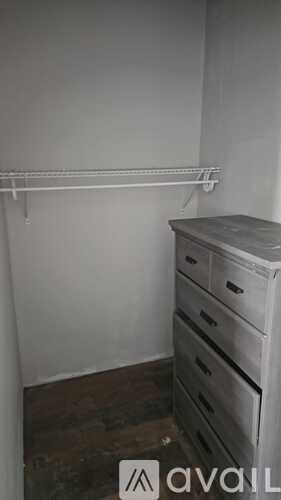 A white shelf and a white dresser in a room.