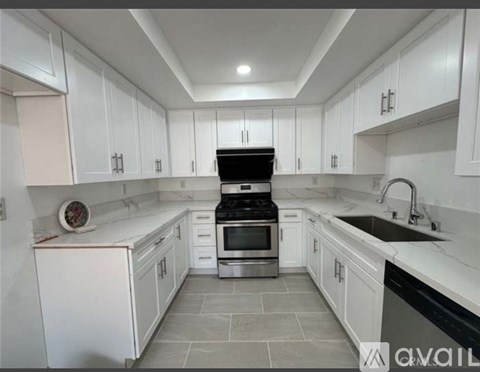 A kitchen with white cabinets and a black stove top oven.