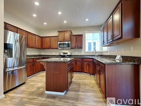 A kitchen with wooden cabinets and a granite countertop.