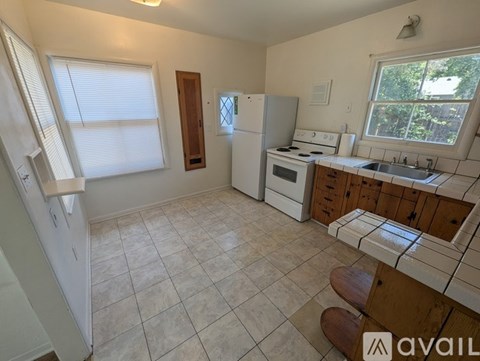 A kitchen with white appliances and wooden cabinets.