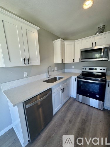 A kitchen with white cabinets and stainless steel appliances.