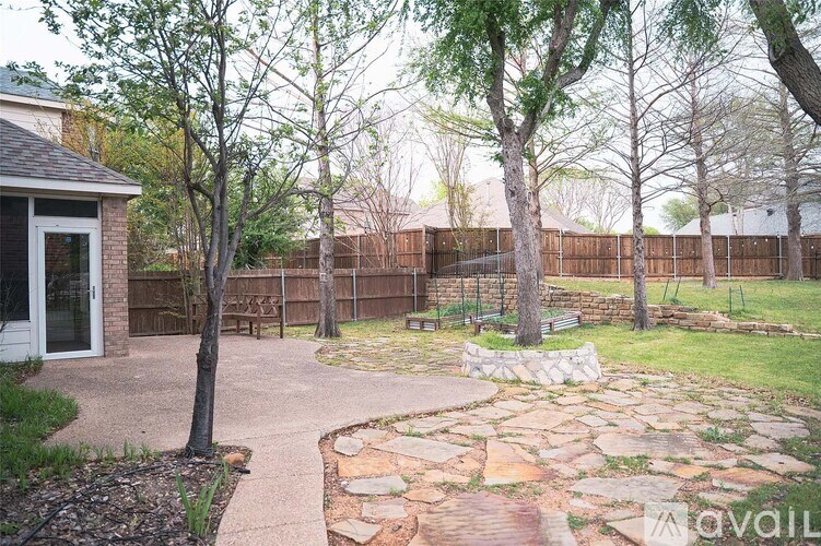 A backyard with a stone pathway and a small building.