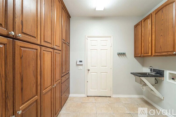 A kitchen with wooden cabinets and a white door.