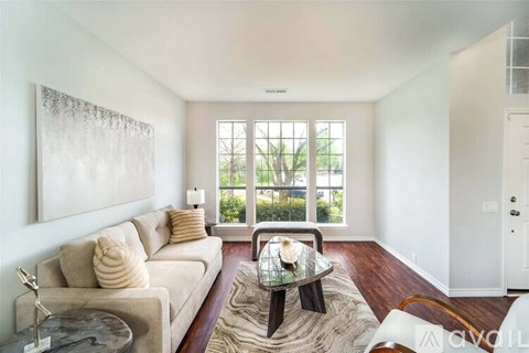 A living room with a couch, coffee table, and a painting on the wall.