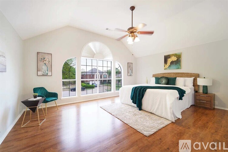 A bedroom with a large bed and a ceiling fan.