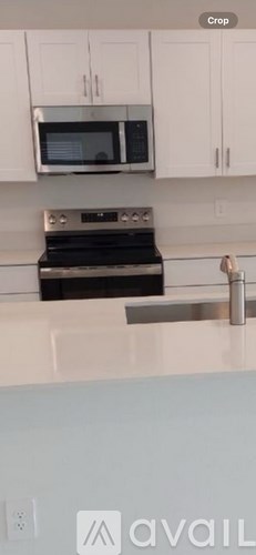 A kitchen with white cabinets and a black stove top oven.