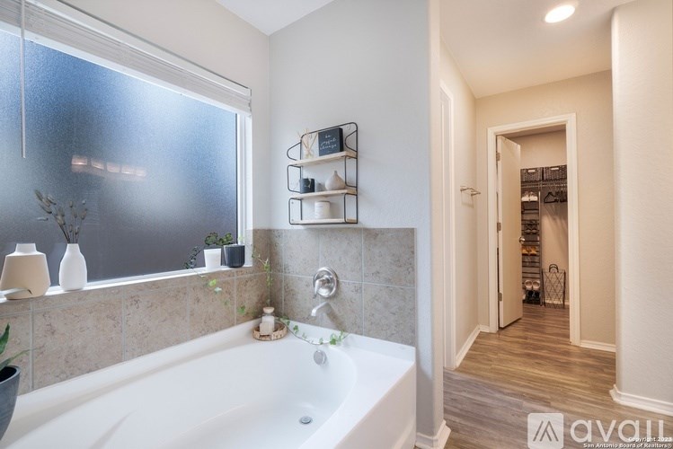 A bathroom with a tub and a window.