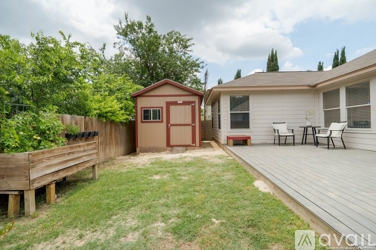 A backyard with a wooden deck and a small shed.