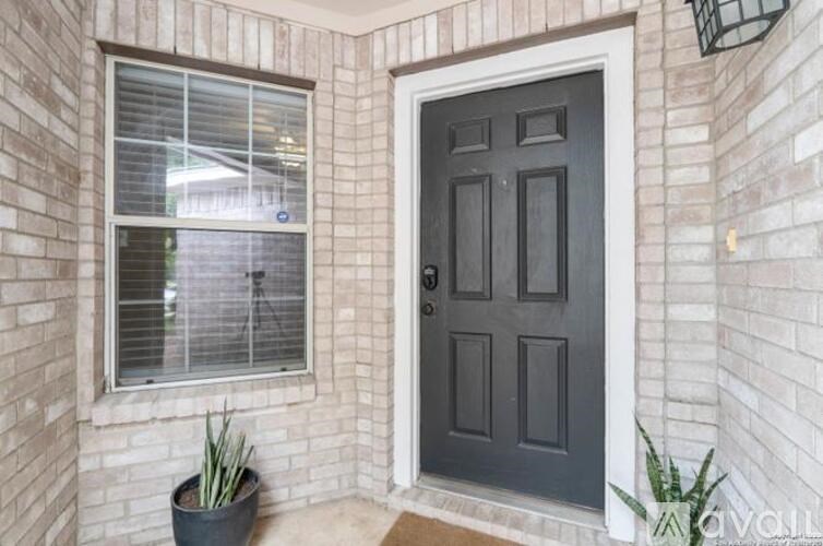 A black door is on the right and a window with blinds is on the left.