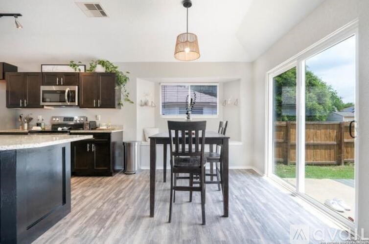 A kitchen with a black chair and a black counter.