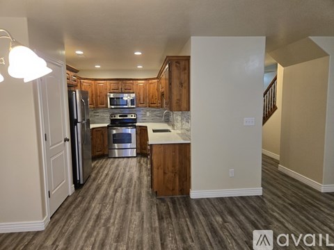 A kitchen with wood cabinets and a stainless steel refrigerator.