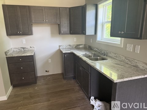 A kitchen with dark cabinets and a marble countertop.