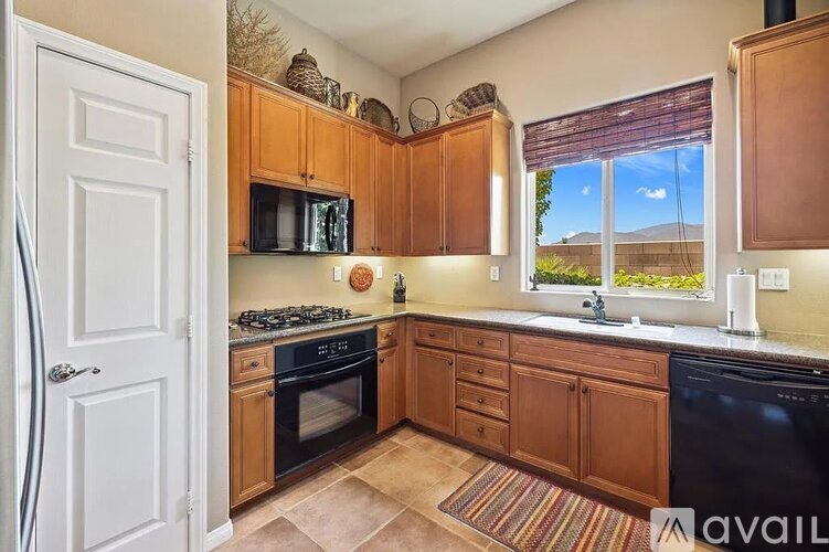 A kitchen with wooden cabinets and black appliances.