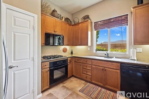 A kitchen with wooden cabinets and black appliances.