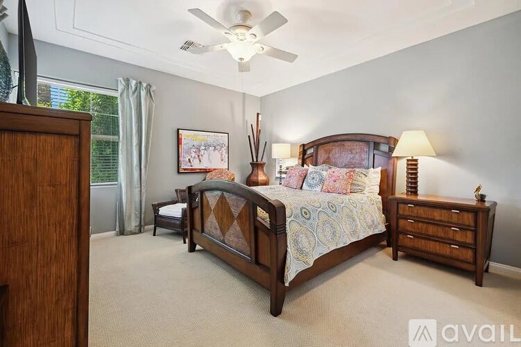 A bedroom with a large bed and a ceiling fan.
