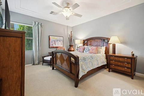 A bedroom with a large bed and a ceiling fan.