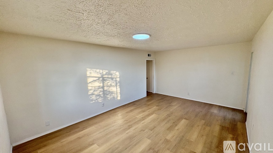 A room with wooden flooring and a window letting in natural light.