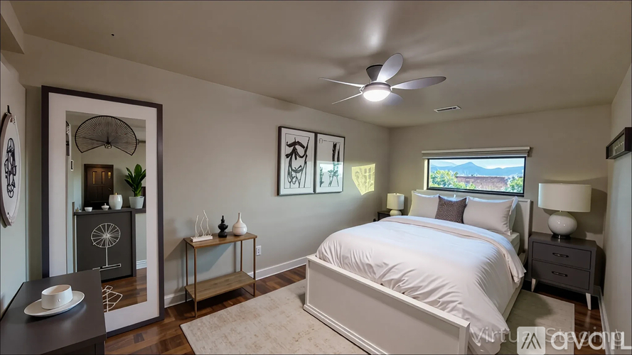 A bedroom with a large bed, a ceiling fan, and a window with a view of the outdoors.