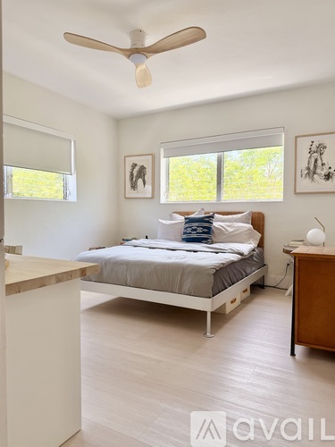A bedroom with a bed, chair, and window.