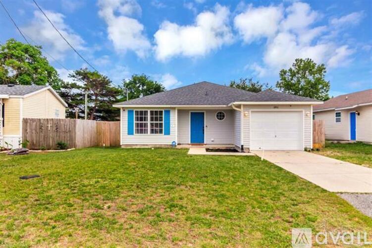 A house with a blue door and garage door is for sale.