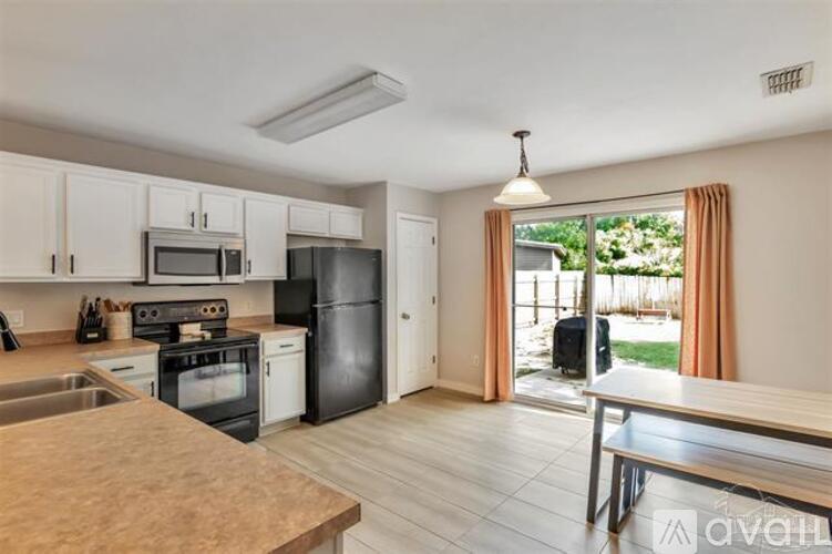 A kitchen with white cabinets and black appliances.