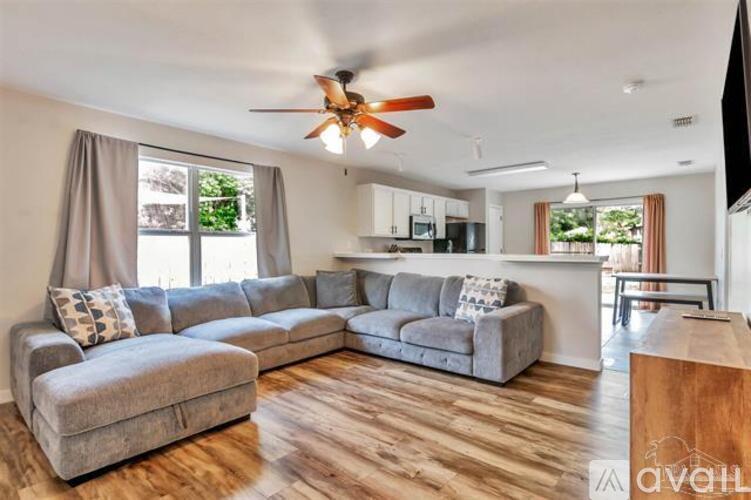 A living room with a grey sectional sofa and a wooden floor.