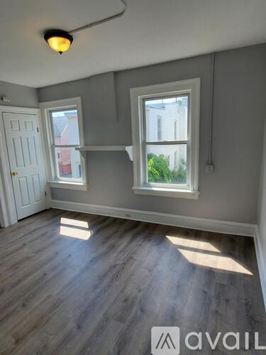 A room with a grey wall and a white door.