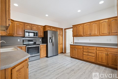 A kitchen with wooden cabinets and stainless steel appliances.