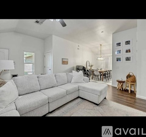 A living room with a grey sofa and a wooden chair.