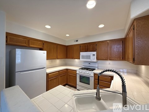 A kitchen with wooden cabinets and a white sink.