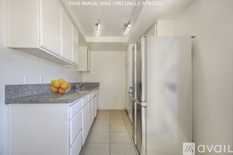 A kitchen with white cabinets and a granite countertop.
