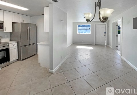 A kitchen with white cabinets and a refrigerator.
