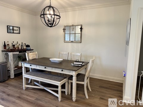 A dining room with a wooden table and chairs.
