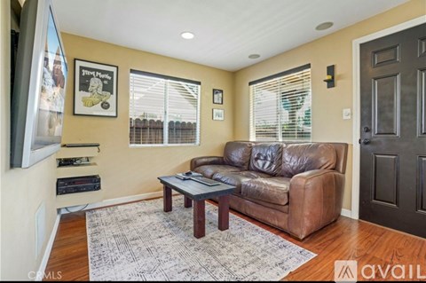 A living room with a brown leather couch and a coffee table.