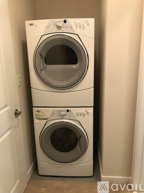 Two white front load washing machines in a laundry room.