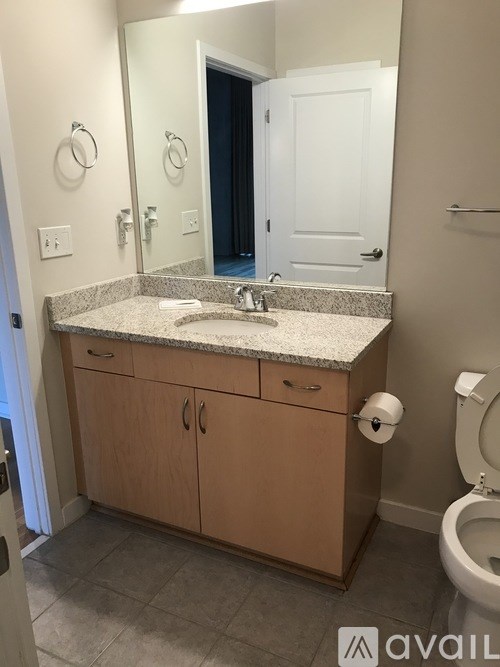 A bathroom with a sink, toilet and mirror.