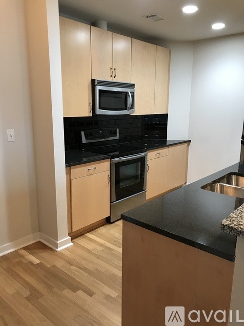 A kitchen with wooden cabinets and black countertops.