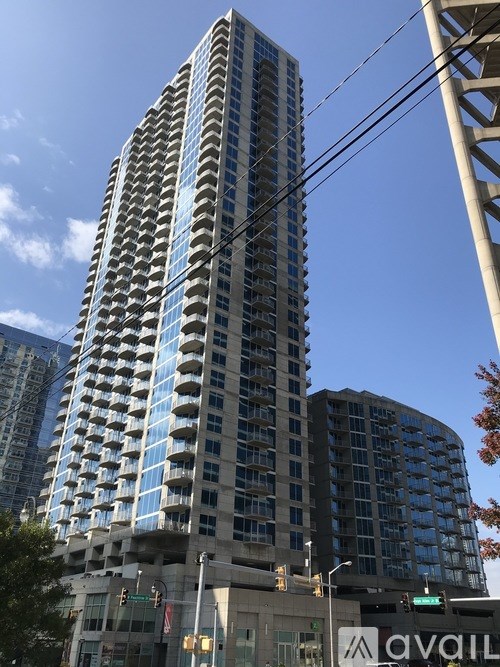 A tall building with many windows is under a clear blue sky.