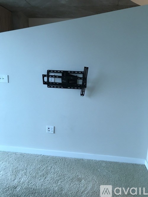 A wall-mounted TV stand is installed on a white wall.