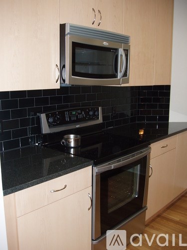 A kitchen with a black counter top and a stove with an oven.