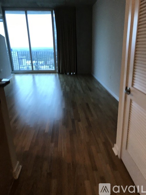 A room with wooden floors and a view of the ocean through the windows.