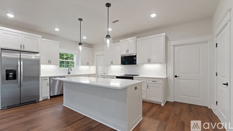 A modern kitchen with white cabinets and a central island.